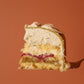 Slice of layered cake on a fork against an orange background