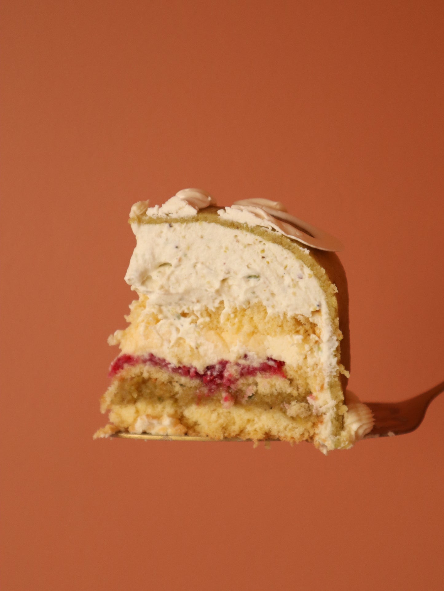 Slice of layered cake on a fork against an orange background
