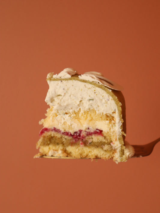 Slice of layered cake on a fork against an orange background